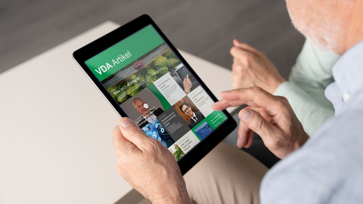 Mann mit iPad, das geöffnete Startseite der VDA-Website zeigt