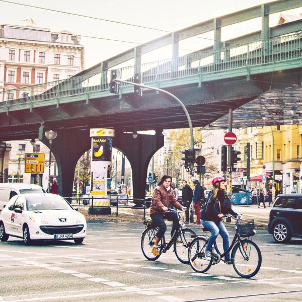 Straßenkreuzung in Berlin mit Radfahrern und Autofahrern