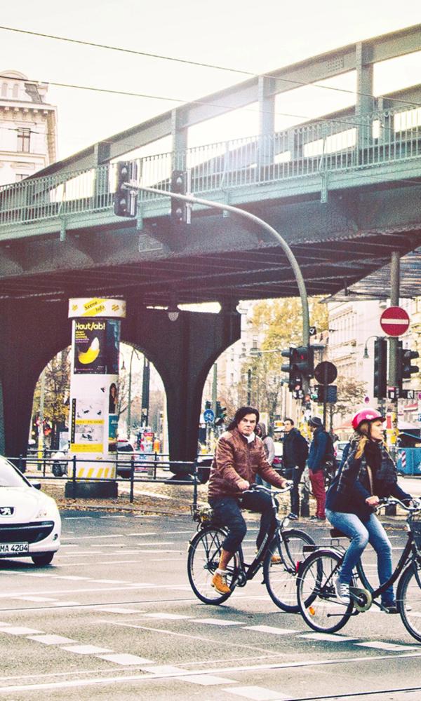Straßenkreuzung in Berlin mit Radfahrern und Autofahrern